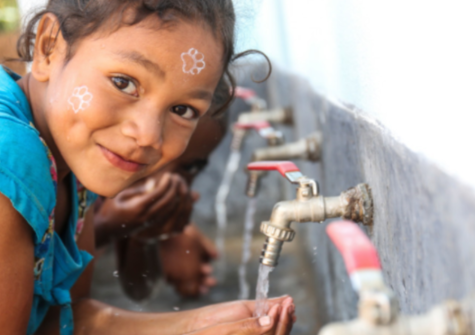 young-girl-washing-her-hands-and-smiling-at-the-camera